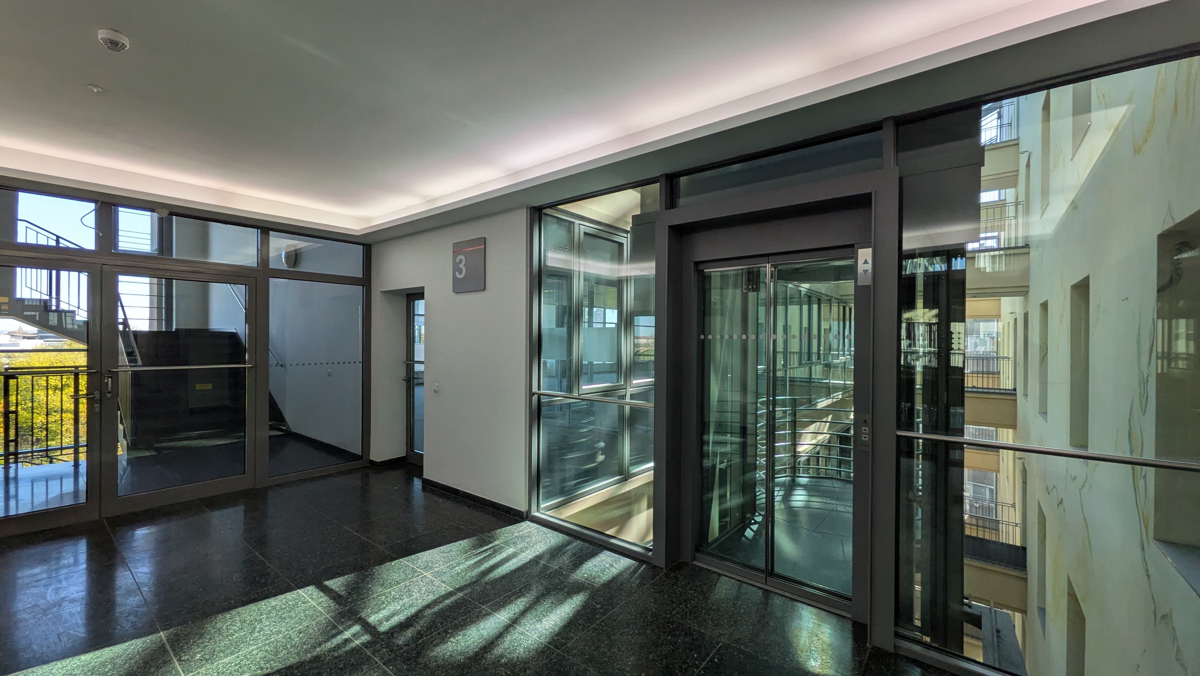 Moderner Eingangsbereich mit Glasaufzug im 3. Obergeschoss des Mediapark 5, Köln